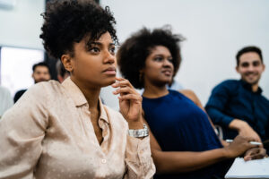 Group of creative business people listening to colleague addressing office meeting. Business and brainstorming concept.